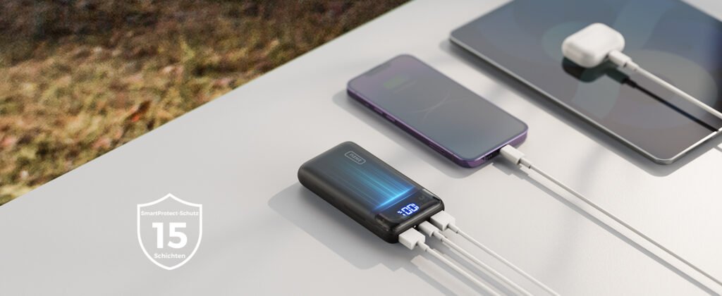 Power bank INIU cargando múltiples dispositivos con indicador LED de batería sobre mesa blanca.