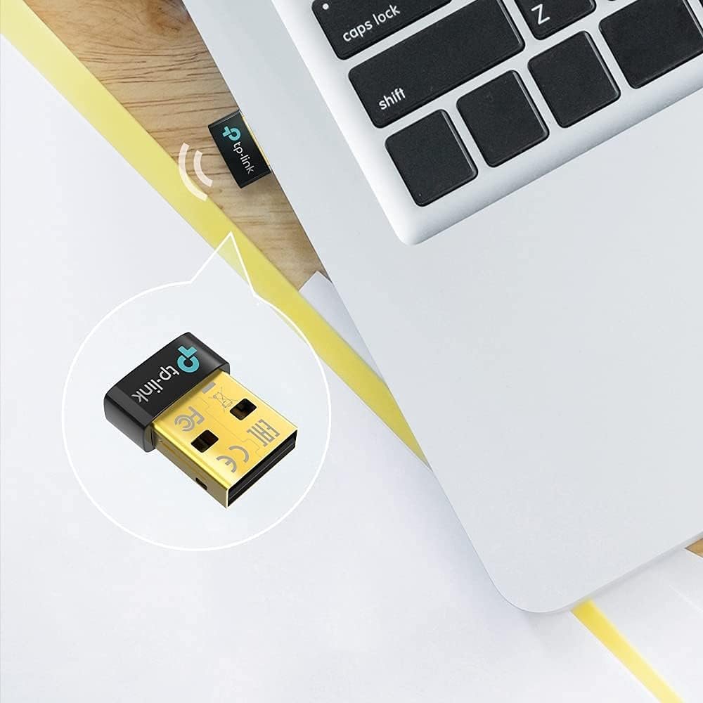 Adaptador USB Bluetooth TP-Link UB500 conectado a una laptop, destacando su diseño compacto y facilidad de uso.